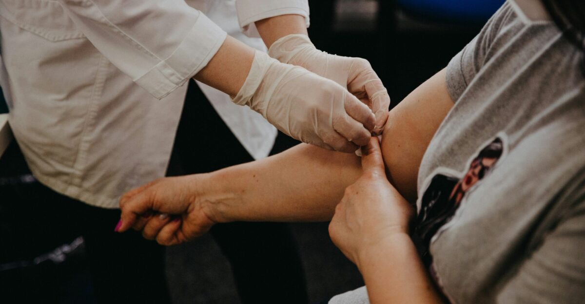 person in white long sleeve shirt holding babys hand