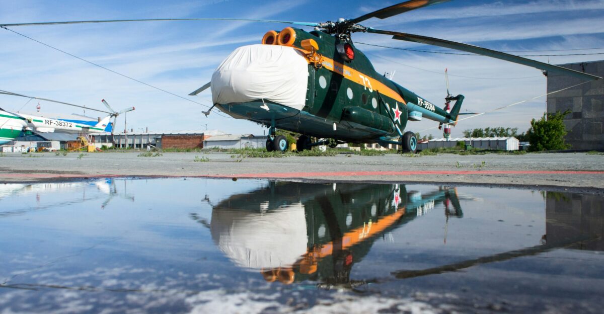 man in white shirt and blue denim jeans standing on green and brown boat during daytime