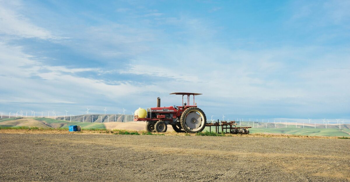 a tractor parked in a field with a blue sky in the background