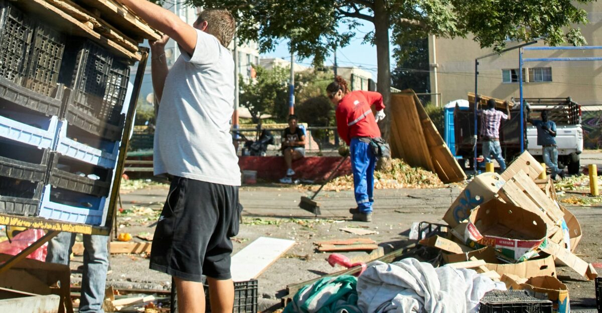 a man standing next to a pile of junk