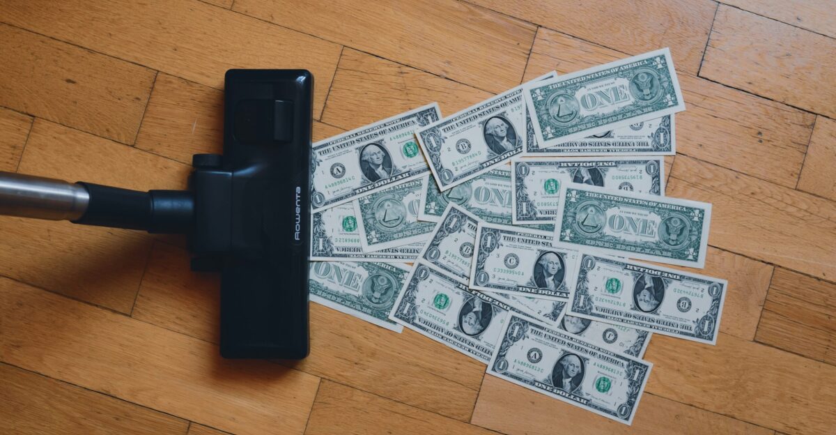a pile of money sitting on top of a wooden floor