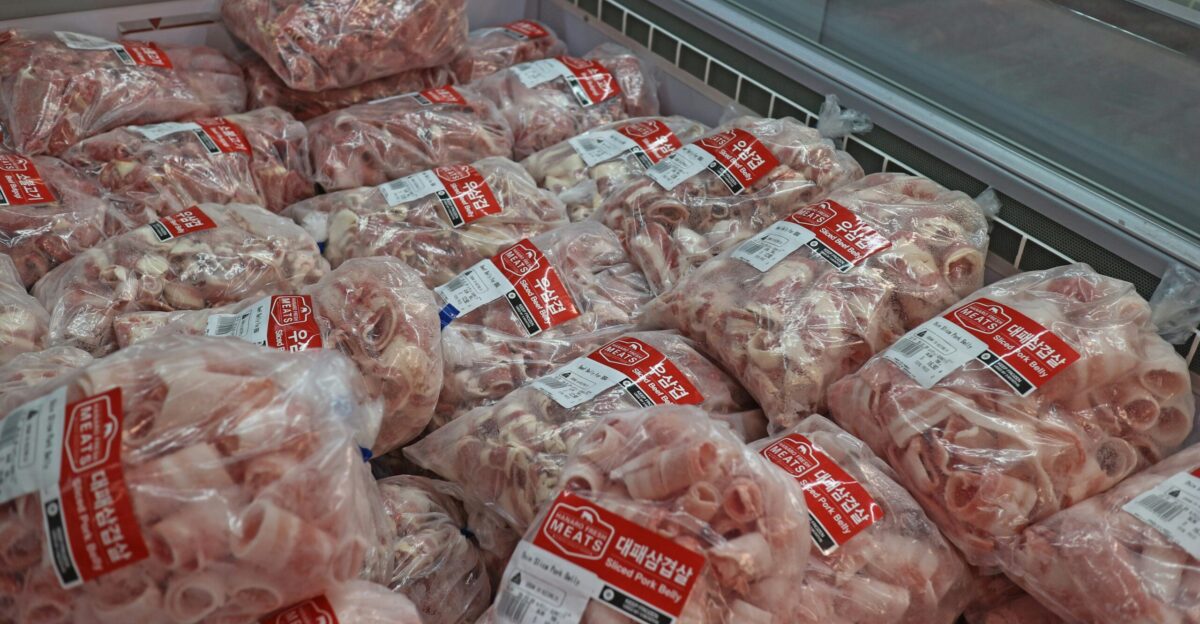a pile of meat wrapped in plastic in a grocery store