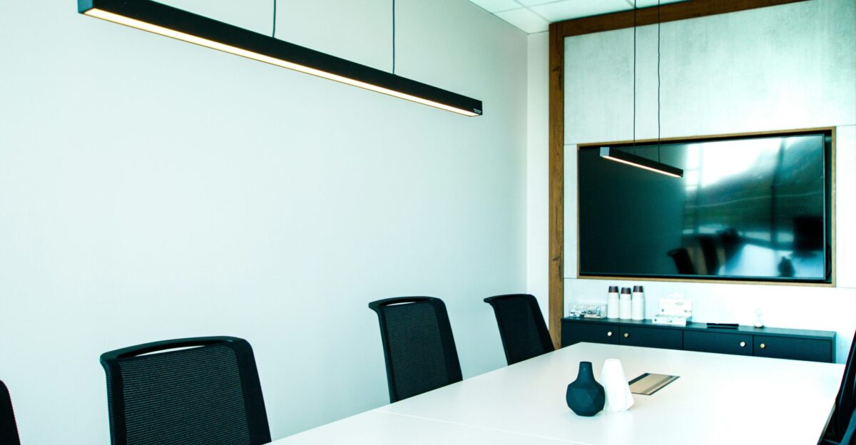 a conference room with a white table and black chairs