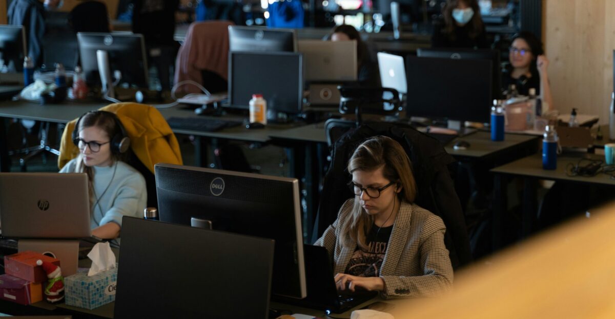 a group of people working on laptops in an office