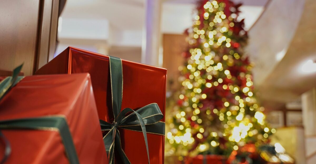 a christmas tree with lights and presents in front of it