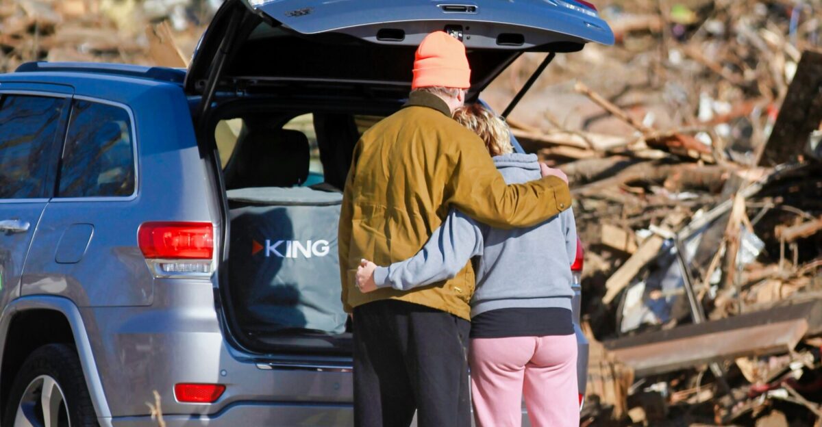 a couple of people standing next to a car