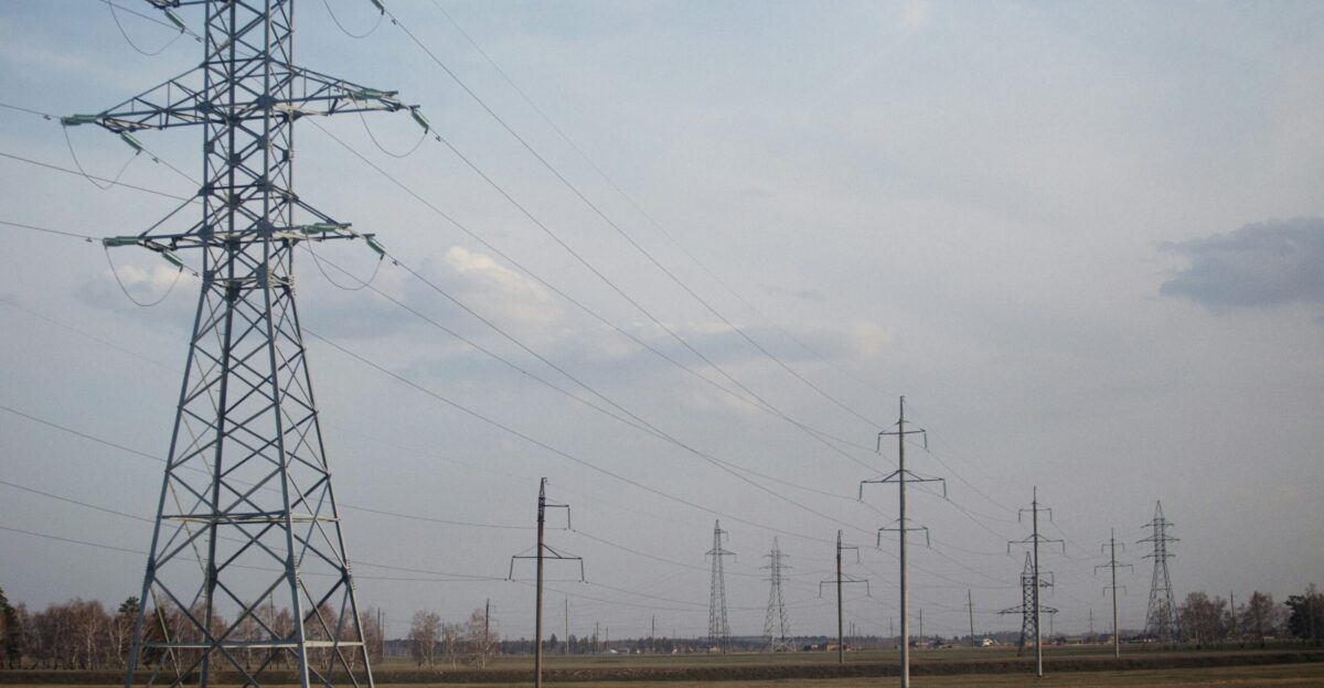 a line of power lines in the middle of a field