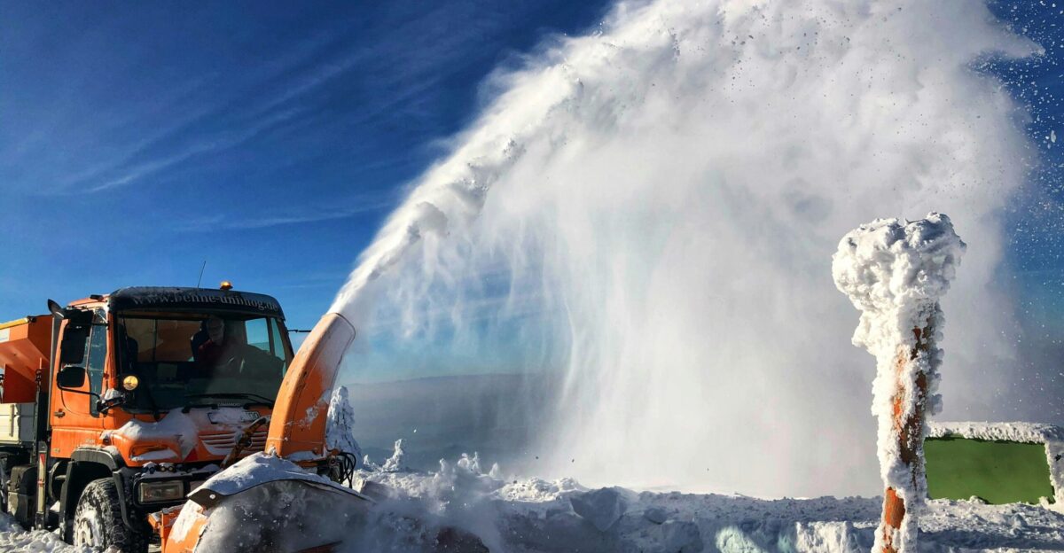 a snow blower is spraying snow onto the ground