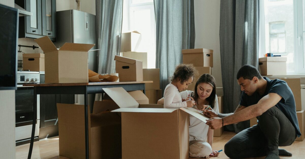 a man and a little girl are sitting on the floor in front of boxes