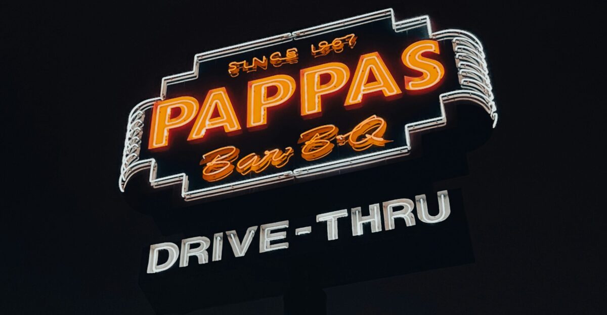 a neon sign for papa s drive thru in the dark