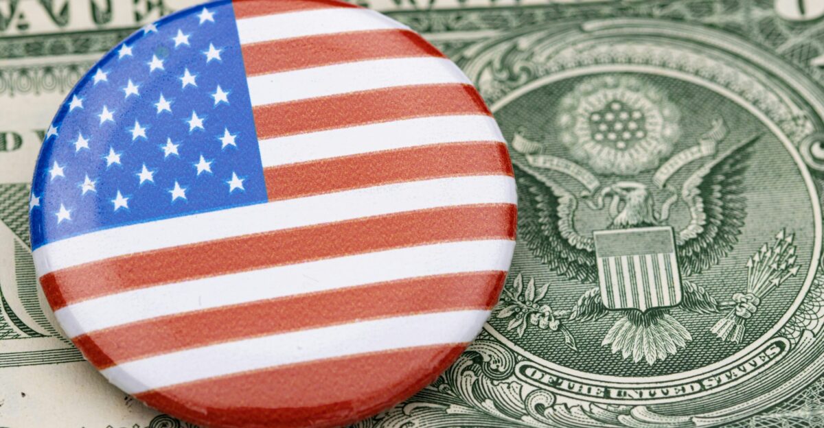 a button with the american flag on top of a dollar bill