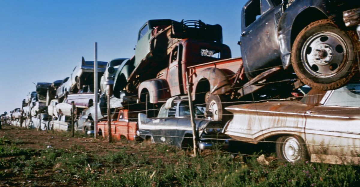 a row of old trucks sitting on top of a grass covered field