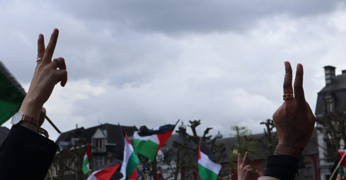 a crowd of people holding their hands up in the air