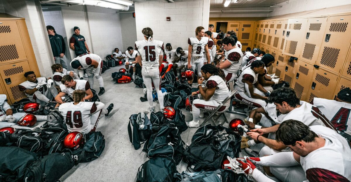 a group of people in a room with many helmets