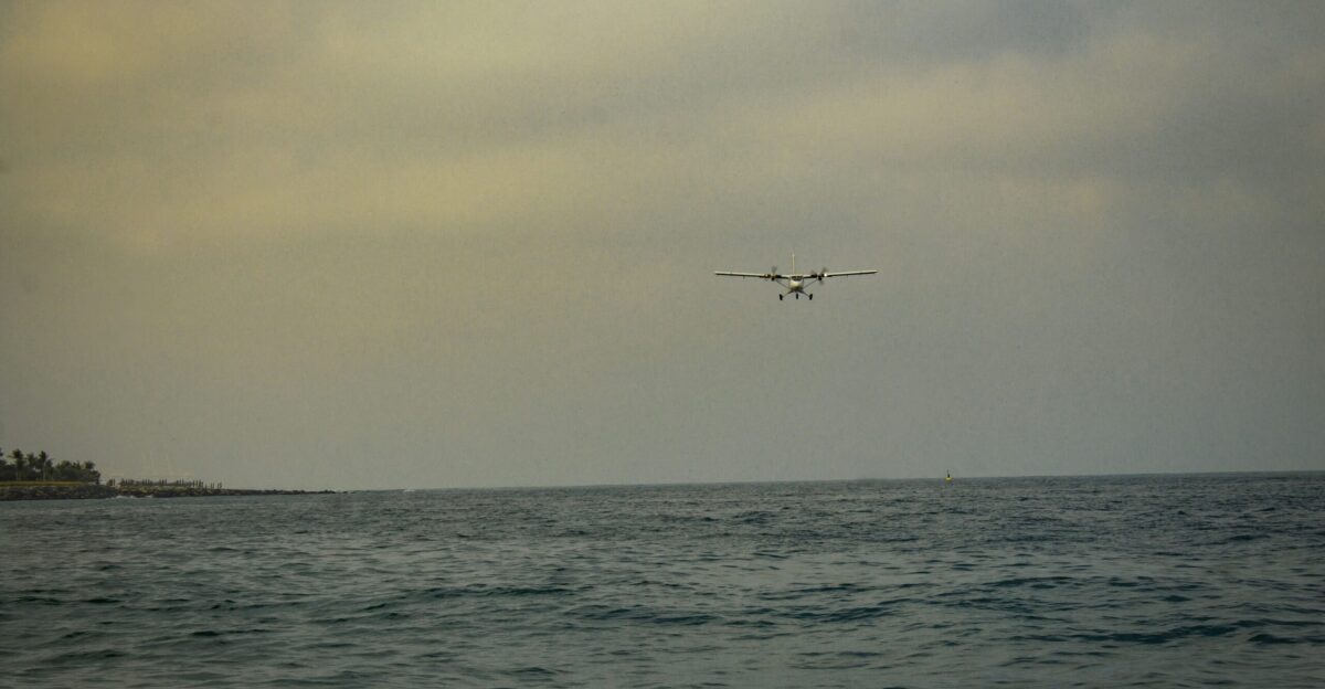 a plane flying over the ocean on a cloudy day