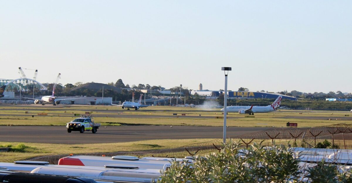 an airport with planes and trucks on the runway