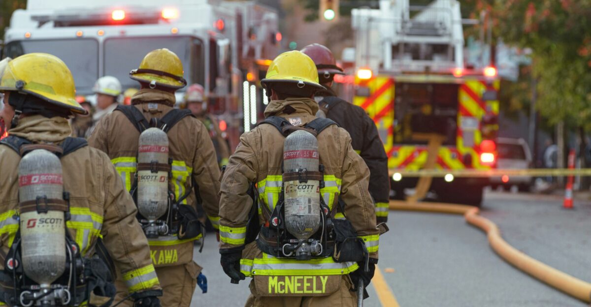 a group of firefighters walking down a street