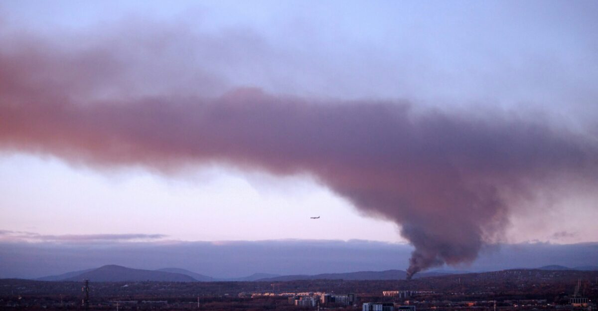 a large plume of smoke billows into the sky