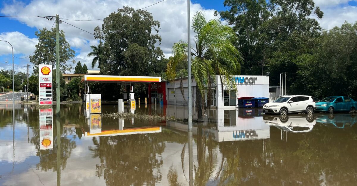 a flooded gas station with cars parked in it
