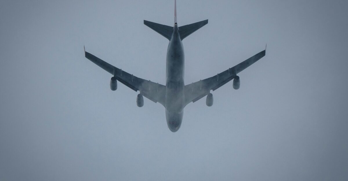 a large jetliner flying through a foggy sky