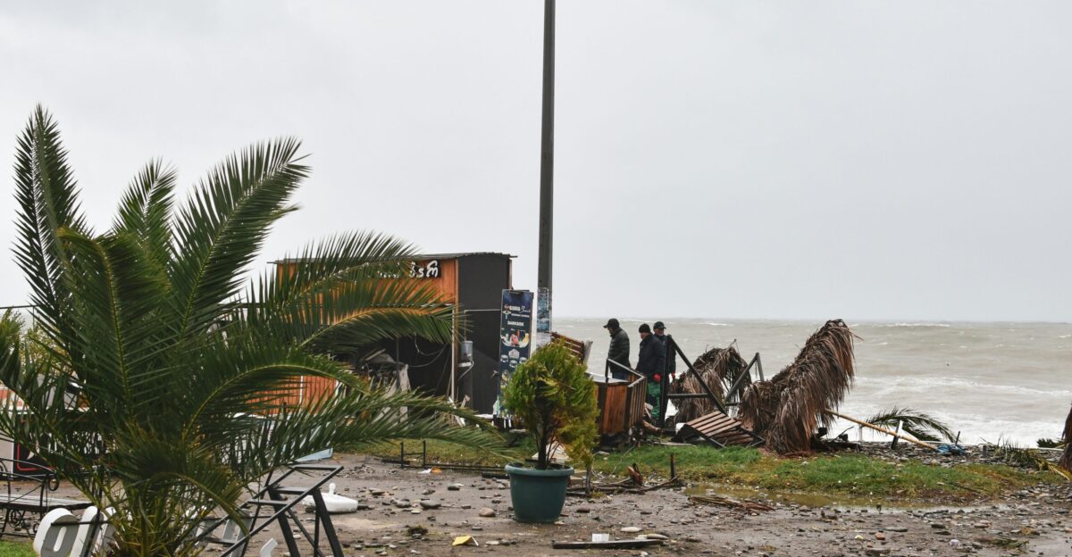 a group of people standing on top of a beach next to the ocean