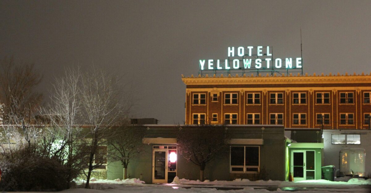 a hotel with a neon sign on top of it