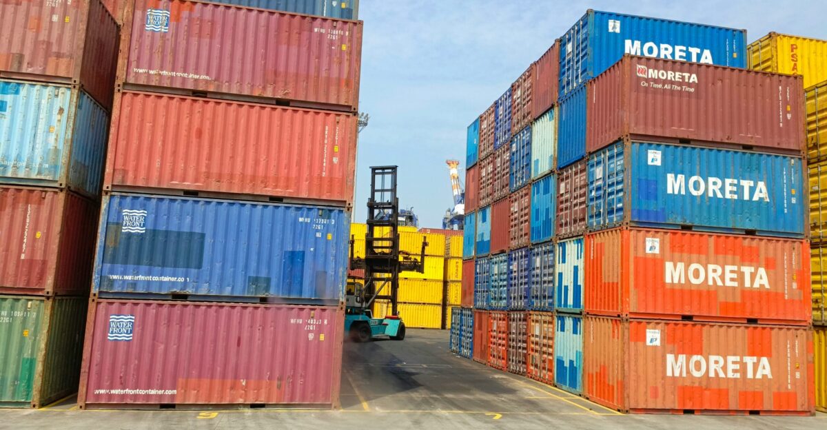 a forklift is moving a large stack of shipping containers