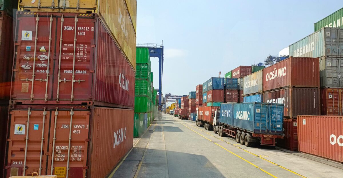 a long line of shipping containers on the side of a road