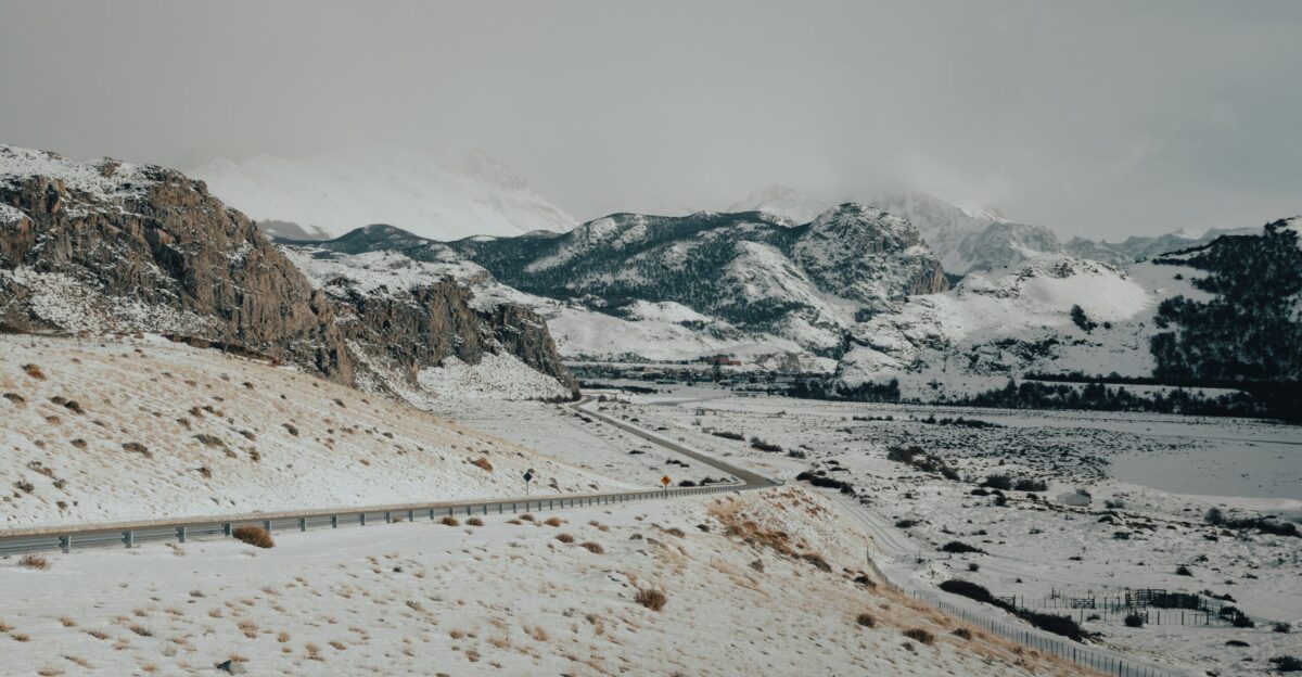a snow covered mountain with a road going through it