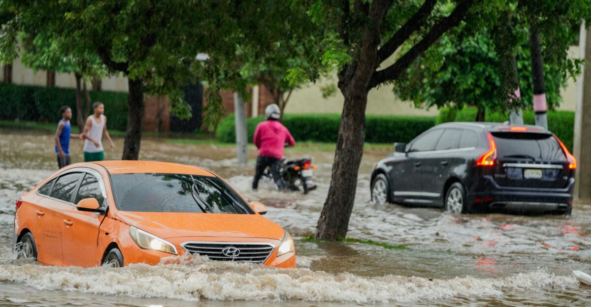 A group of people walking through a flooded street