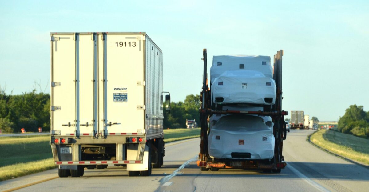 A couple of semi trucks driving down a highway
