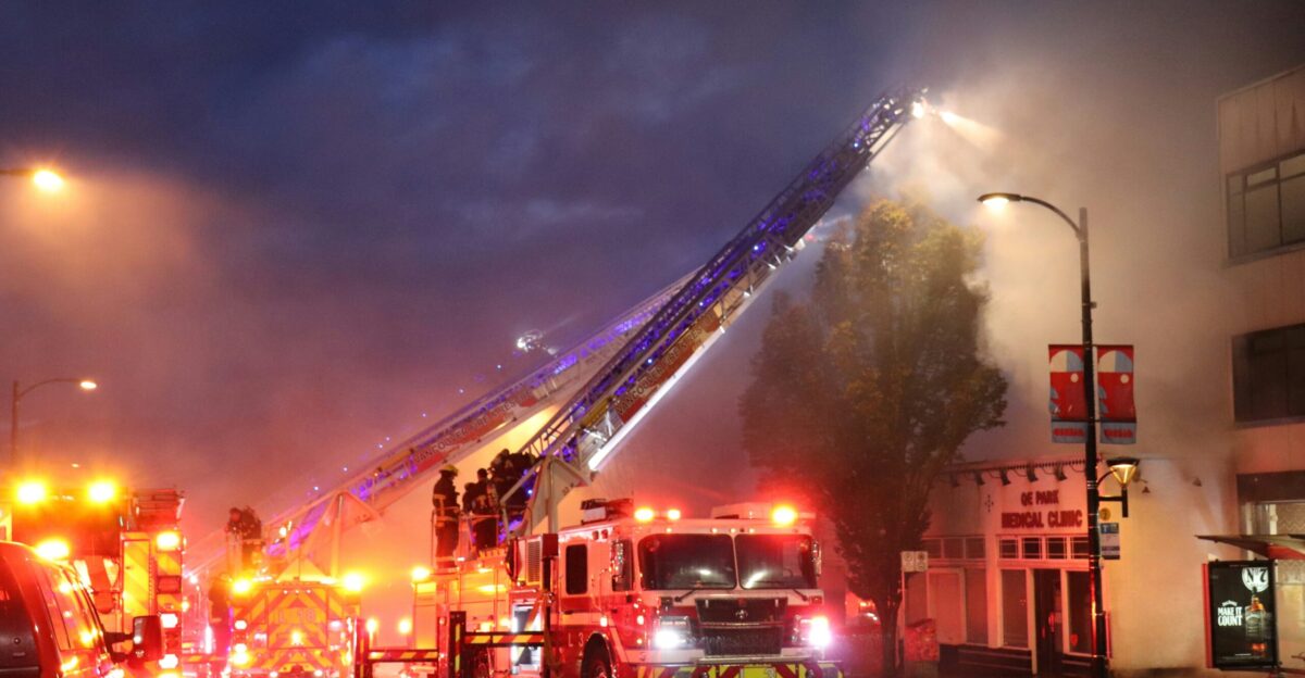 A group of fire trucks driving down a street