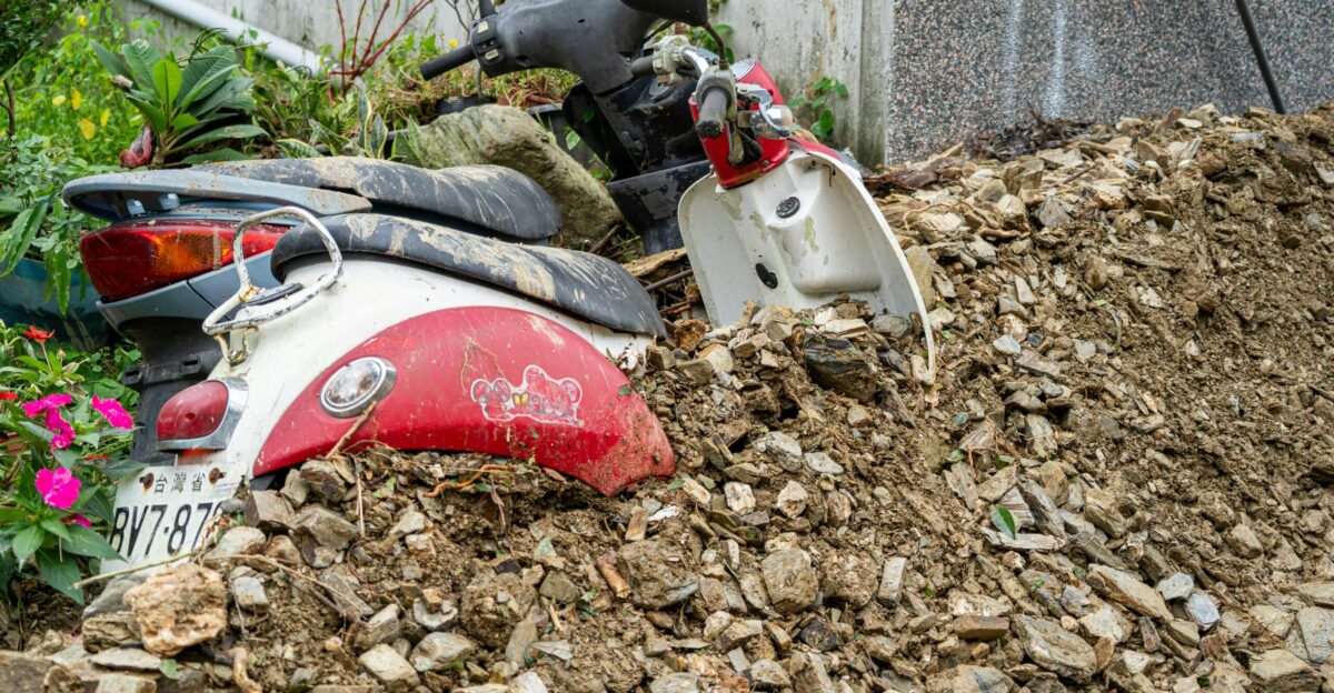 A motor scooter is parked in a pile of rubble