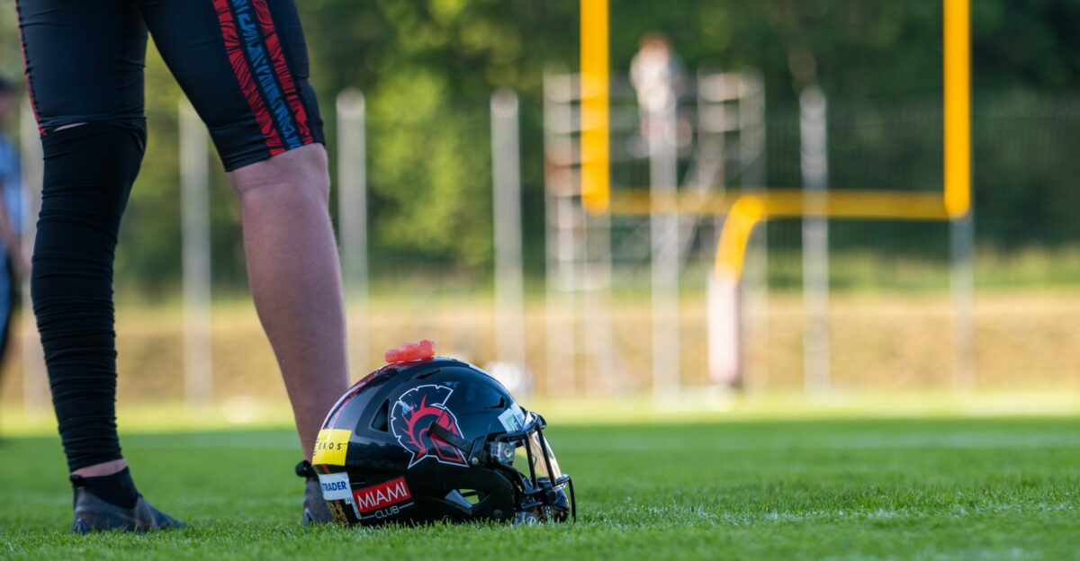 Football player standing with helmet on the field