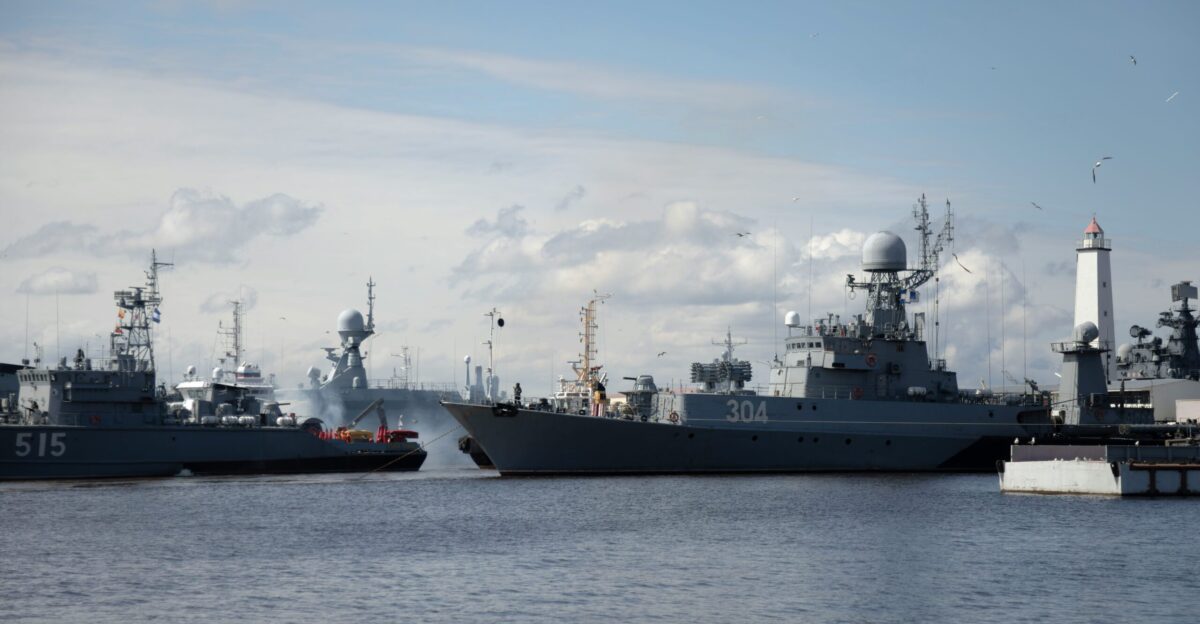 Naval ships are docked at a port