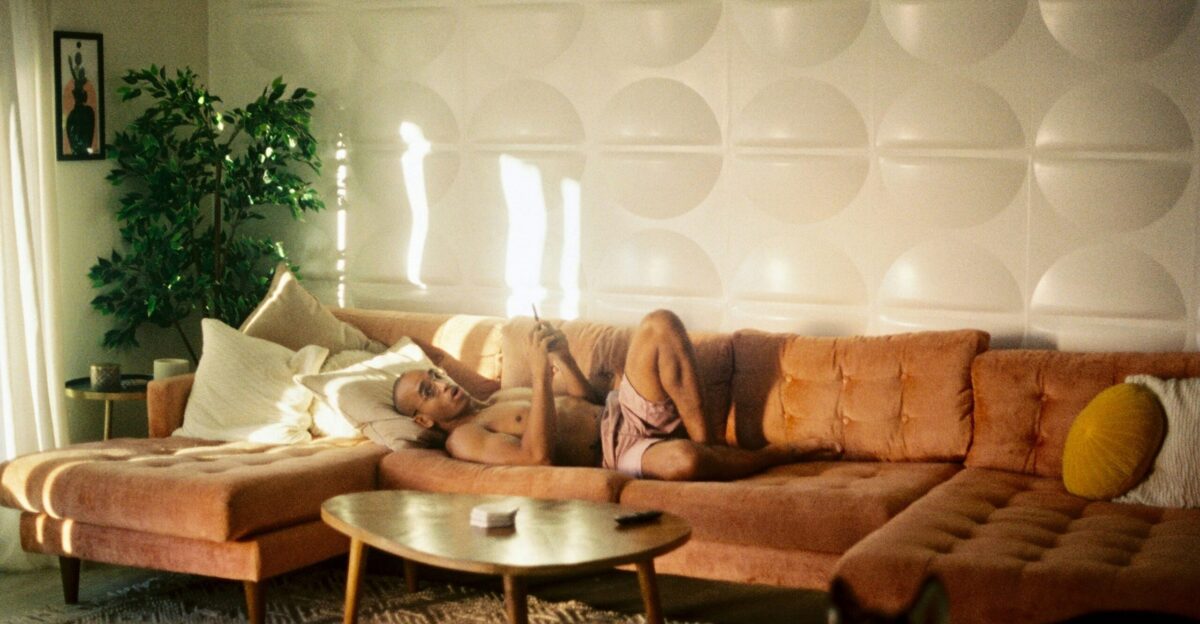 Someone is lounging on a comfy orange couch