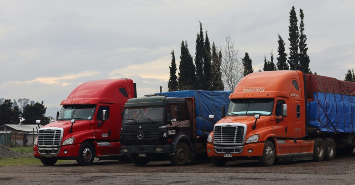 Three trucks are parked in a lot