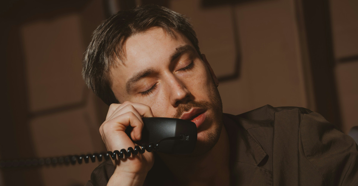 Man leans on the phone appearing sleepy