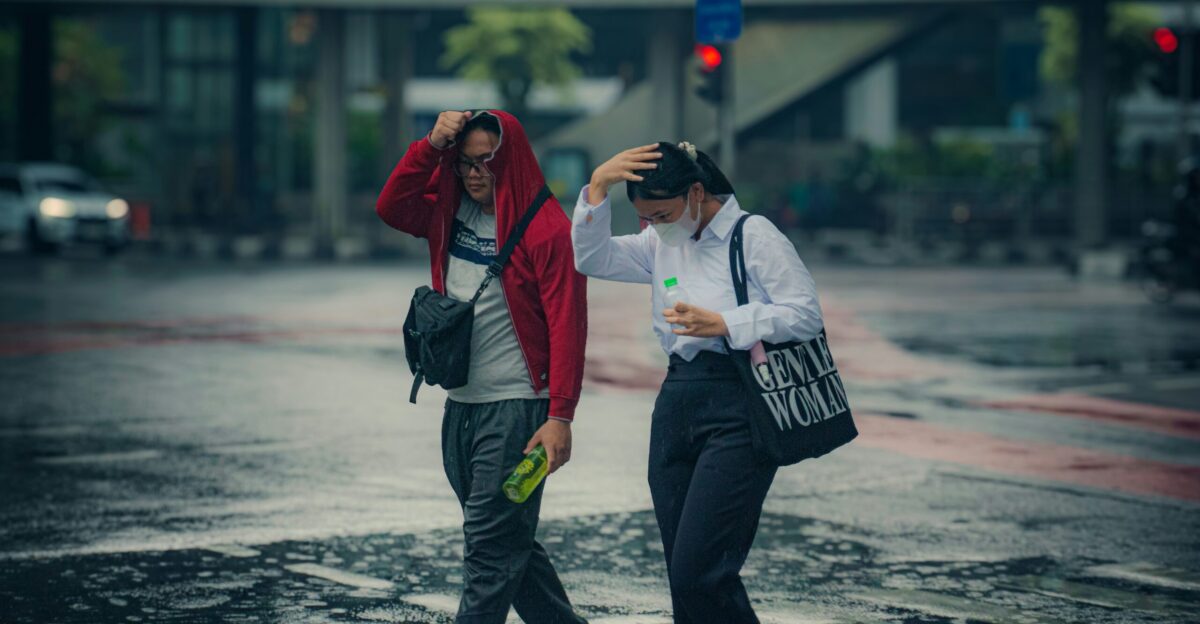 People walk through a flooded street in the rain