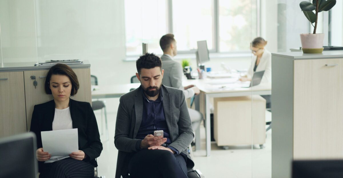 Two people waiting in an office lobby