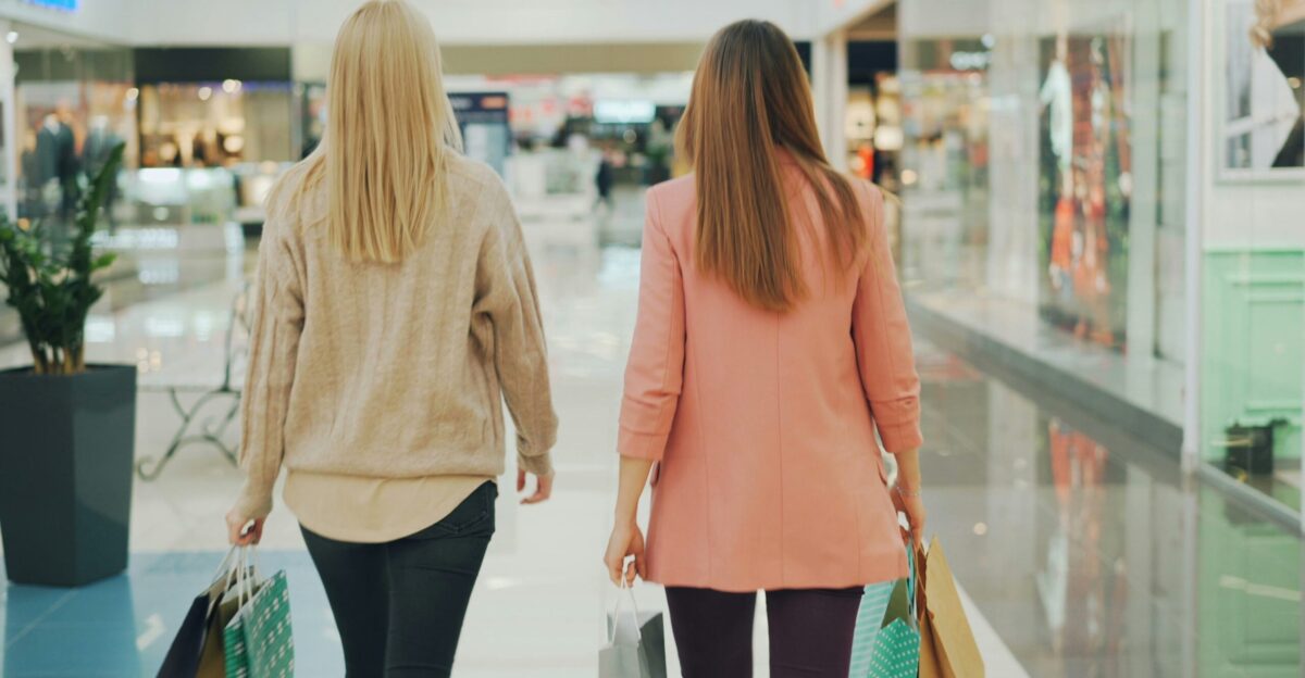 Two women walking in a brightly lit shopping mall