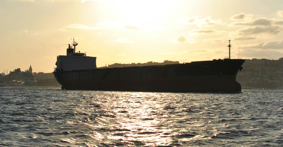 Cargo ship sailing on the ocean at sunset