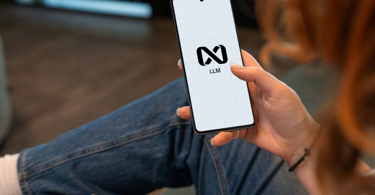 Person holding a smartphone with a logo on screen