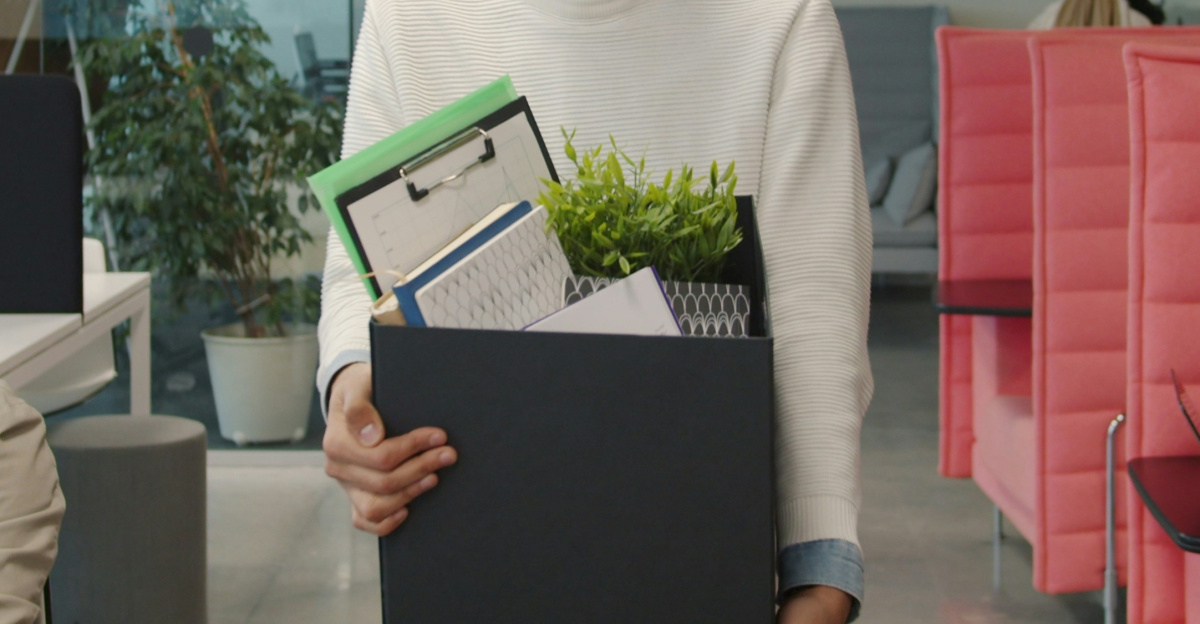 Man carrying box of belongings in modern office