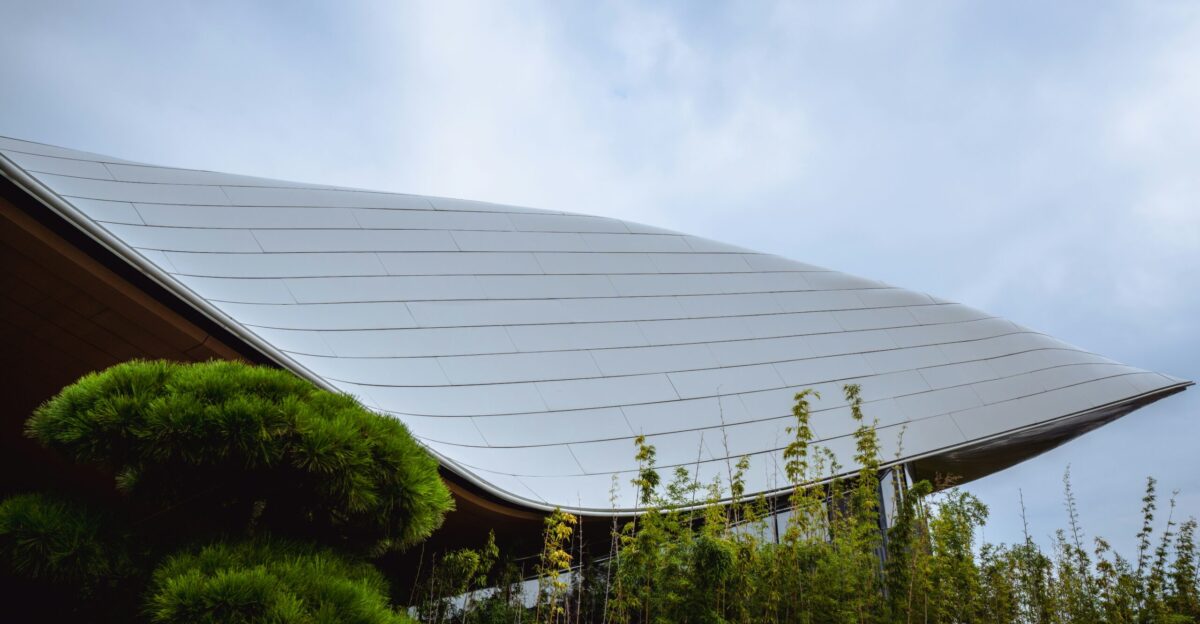 Modern building with curved roof and lush greenery