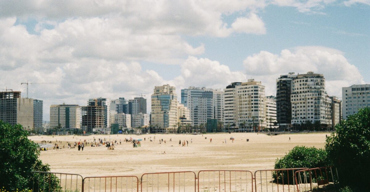 City skyline behind a sandy beach with people