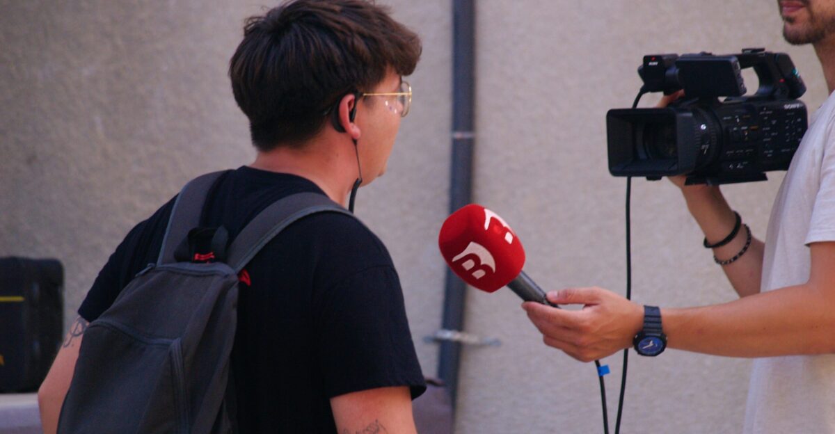 A person being interviewed with a microphone and camera