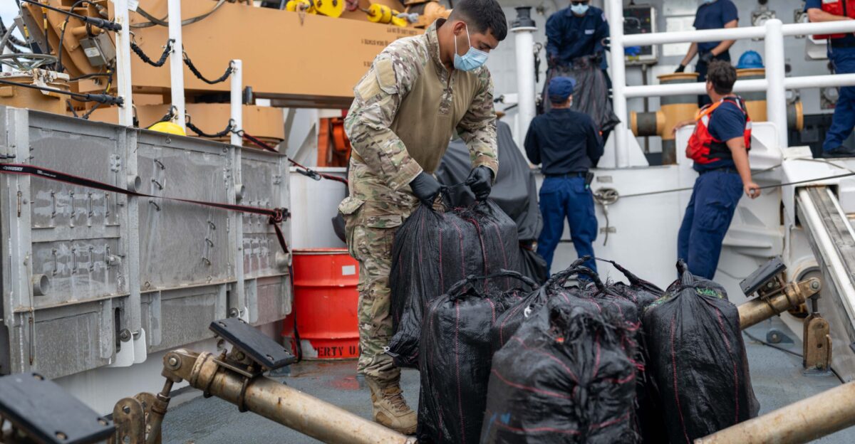 A member of the U S Coast Guard Tactical Law Enforcement Team South moves bales of cocaine off the fantail of U S Coast Guard Cutter Kimball WMSL 756 after receiving interdicted contraband from U S Coast Guard Cutter Forward WMEC 911 while patrolling the Eastern Pacific Ocean March 28 2025 The U S Coast Guard is increasing presence in key areas to secure the U S maritime border against the flow of cocaine fentanyl and other illegal drugs U S Coast Guard photo by Petty Officer 3rd Class Austin Wiley