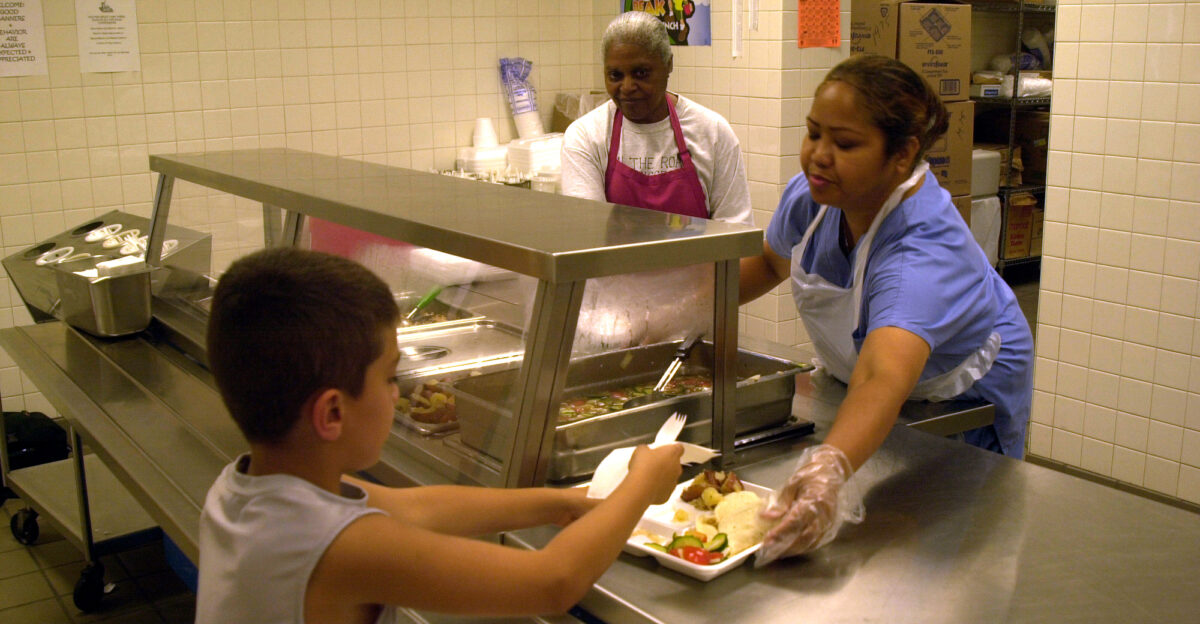 MARINE CORPS BASE CAMP LEJEUNE N C - Aurora Paltt a cafeteria worker at Tarawa Terrace II Elementary School serves a child a lunch here July 11 Preschoolers to 18-year-olds can get a free lunch from Department of Defense Dependent Schools at Tarawa Terrace II Elementary School and Brewster Middle School Official U S Marine Corps photo by Lance Cpl Brandon R Holgersen