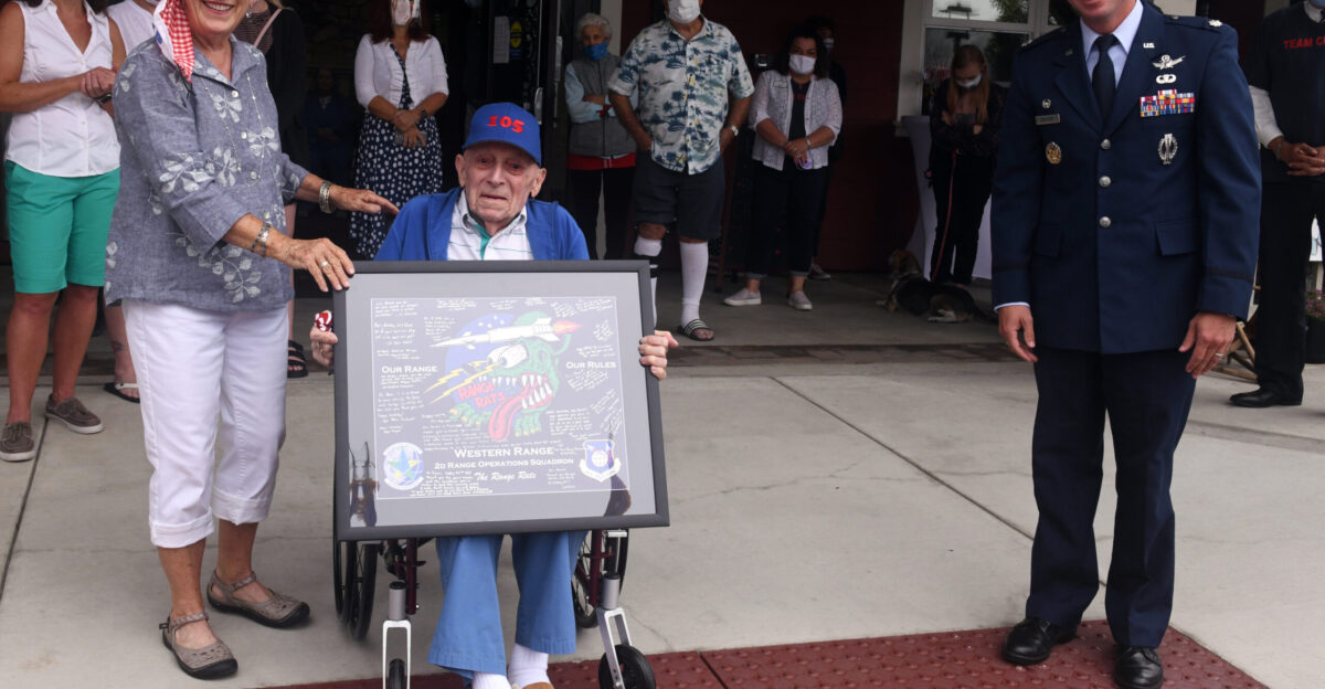 Lt Col Sean Ianacone 2d Range Operations Control Squadron commander and 1st Lt Charles Dever display the squadron lithograph Ianacone presented to Dever during his 105th birthday party Sept 20 2020 in Goleta California U S Air Force photo by Tech Sgt Patrick Harrower